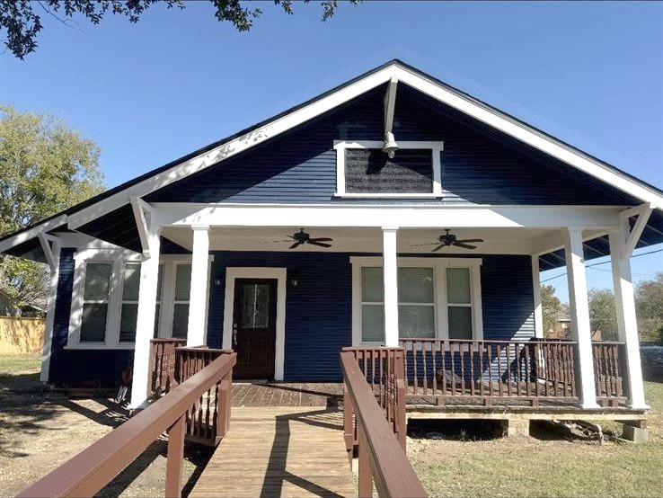 Exterior house painting after, fresh navy siding with crisp white trim and refinished ramp, Brazos Valley, TX (College Station and Bryan)