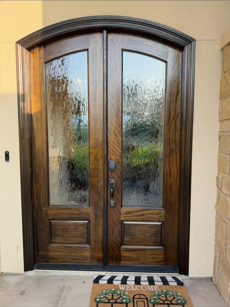 Arched double entry doors after refinishing with a rich stained and clear finish, door staining by a house painter in Brazos Valley, TX