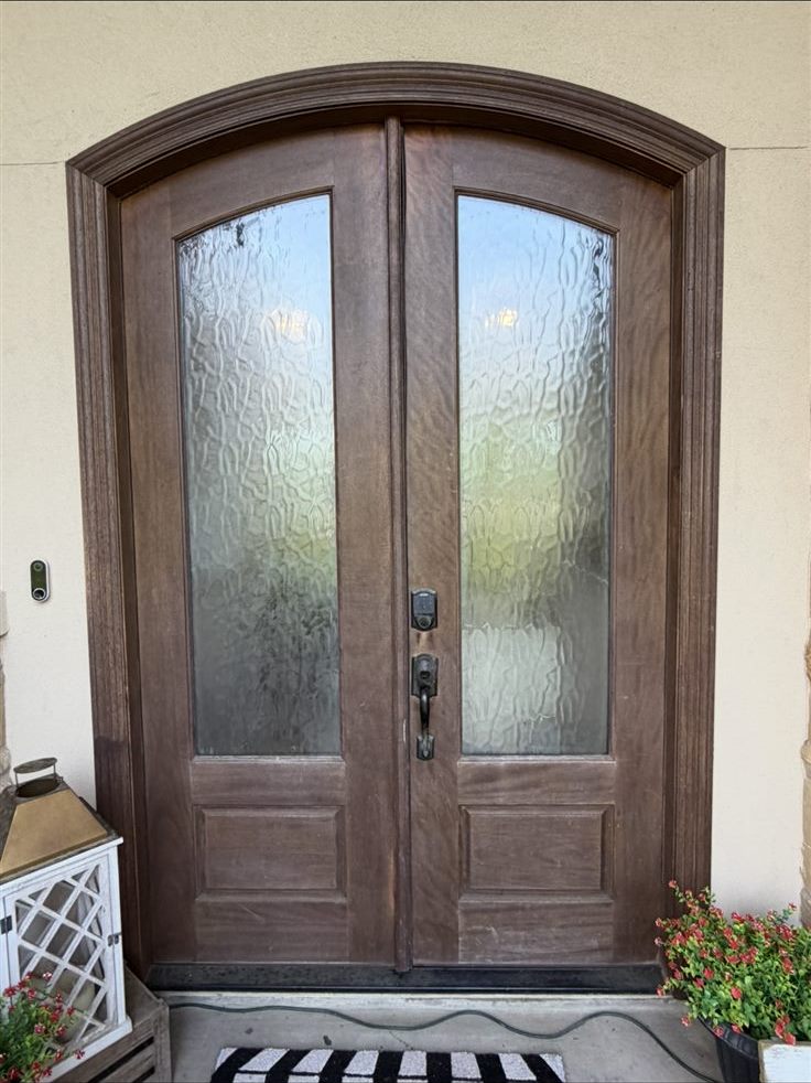 Arched double entry doors before refinishing, faded and sun-worn stain, door staining in the Brazos Valley, TX (College Station and Bryan)