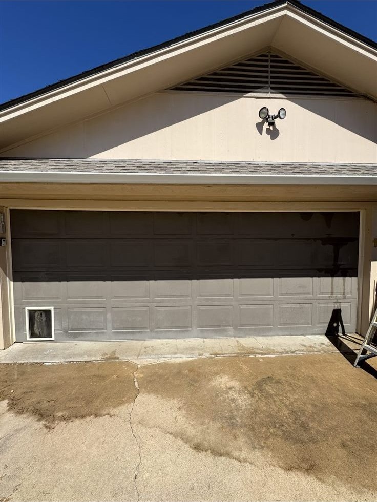 Garage door and home exterior before repainting, faded and mismatched panel color, house painter project in the Brazos Valley, TX (College Station and Bryan)