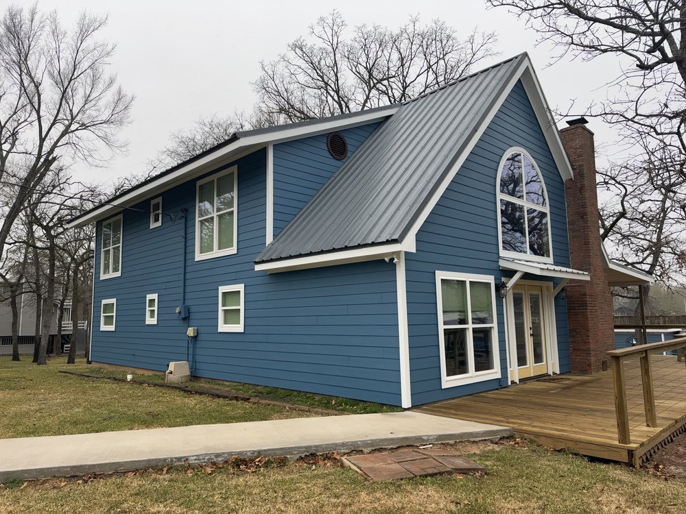 Freshly repainted home exterior in blue with a covered back deck, full exterior repaint, an example of Professional Edge Painting's work in the Brazos Valley, TX (College Station and Bryan)